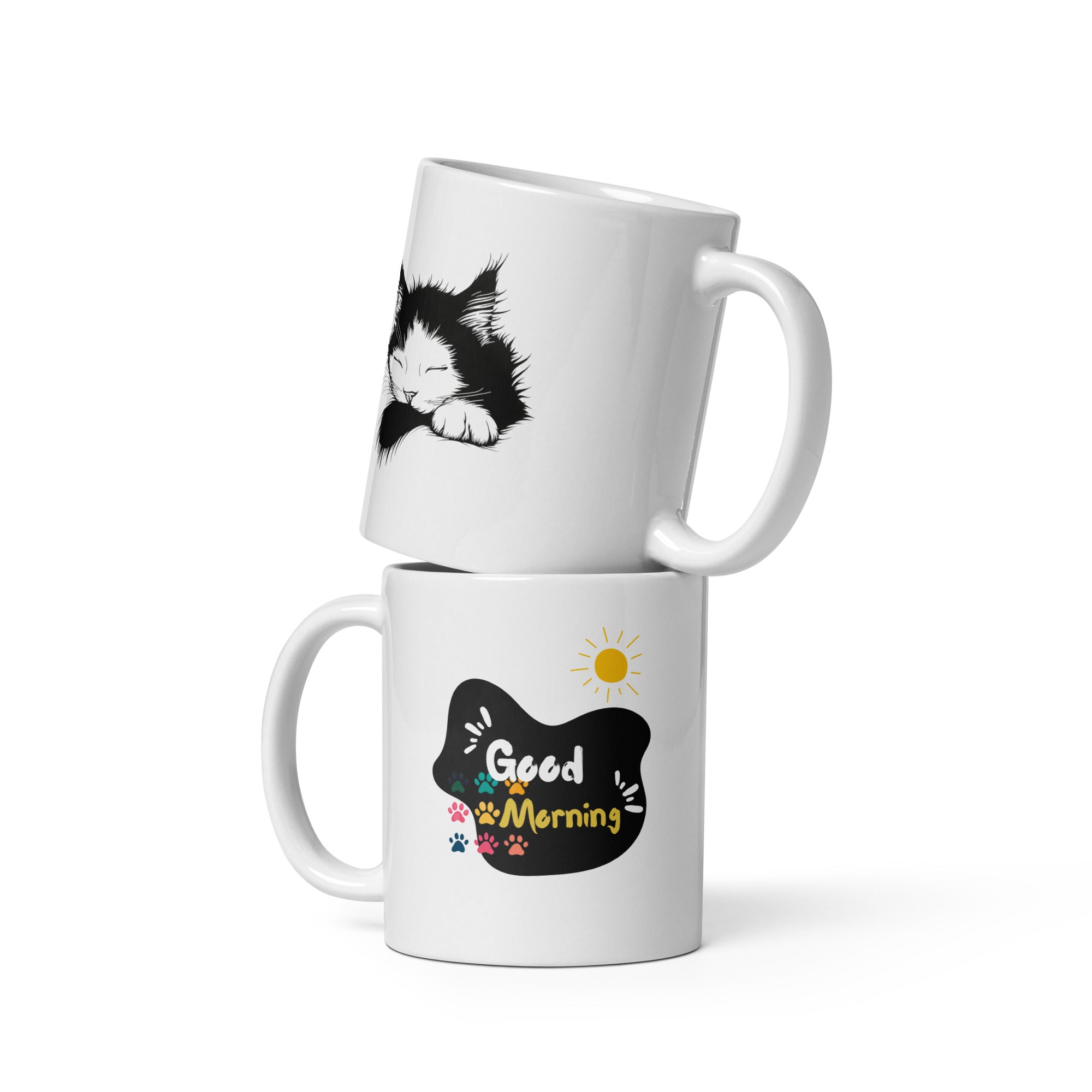 Two ceramic mugs, one with a 'Good Morning' design featuring paw prints and a sun, and the other with a black and white sleeping kitten design.