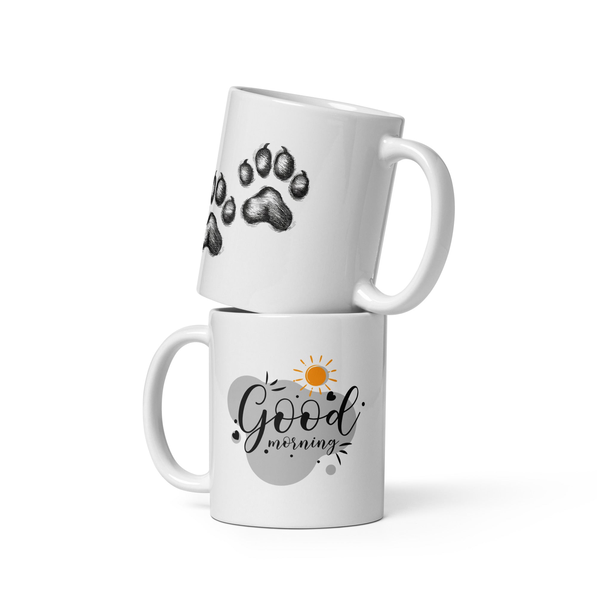 A set of two ceramic mugs, one with a black paw print design on a white background and the other with a 'Good Morning' message alongside a sun and paw accent on a blue background.
