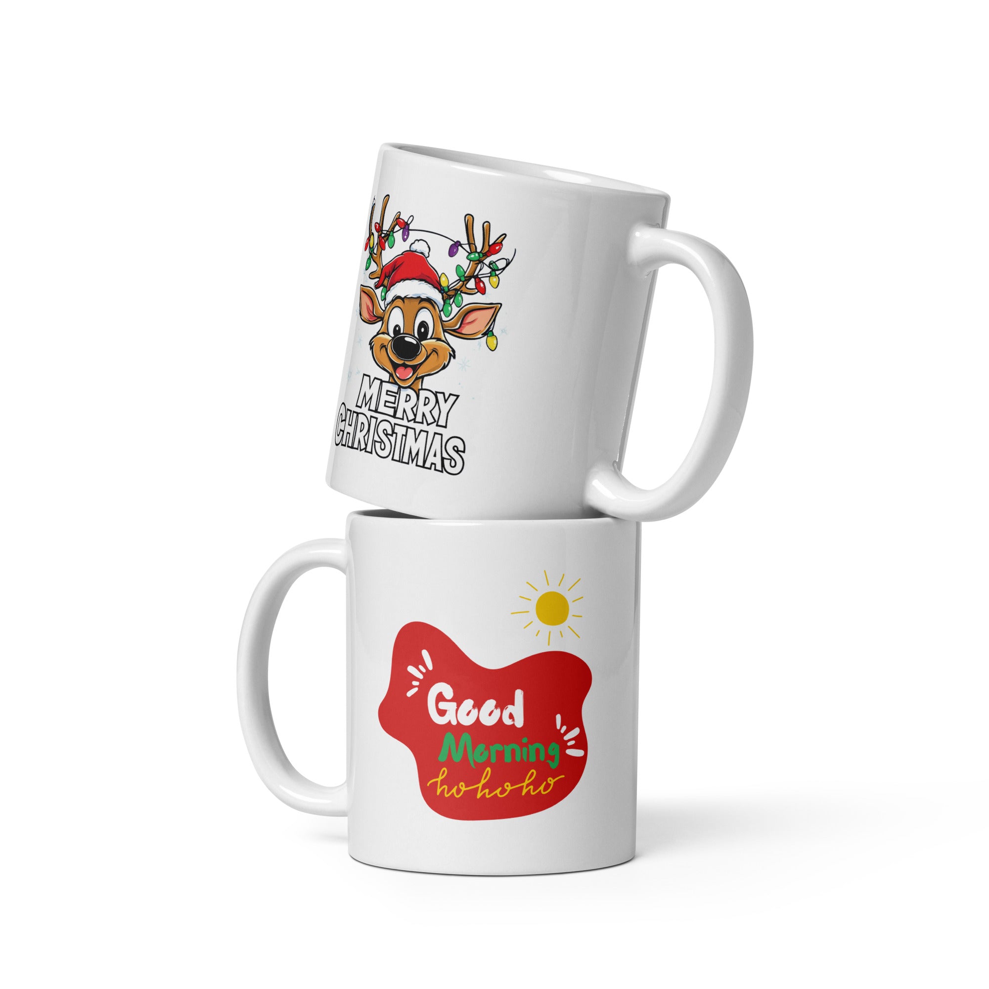 Two ceramic coffee mugs with festive Christmas designs. One mug has a reindeer with a Santa hat and 'Merry Christmas' text, and the other mug has a sun with 'Good Morning Ho Ho Ho' text.