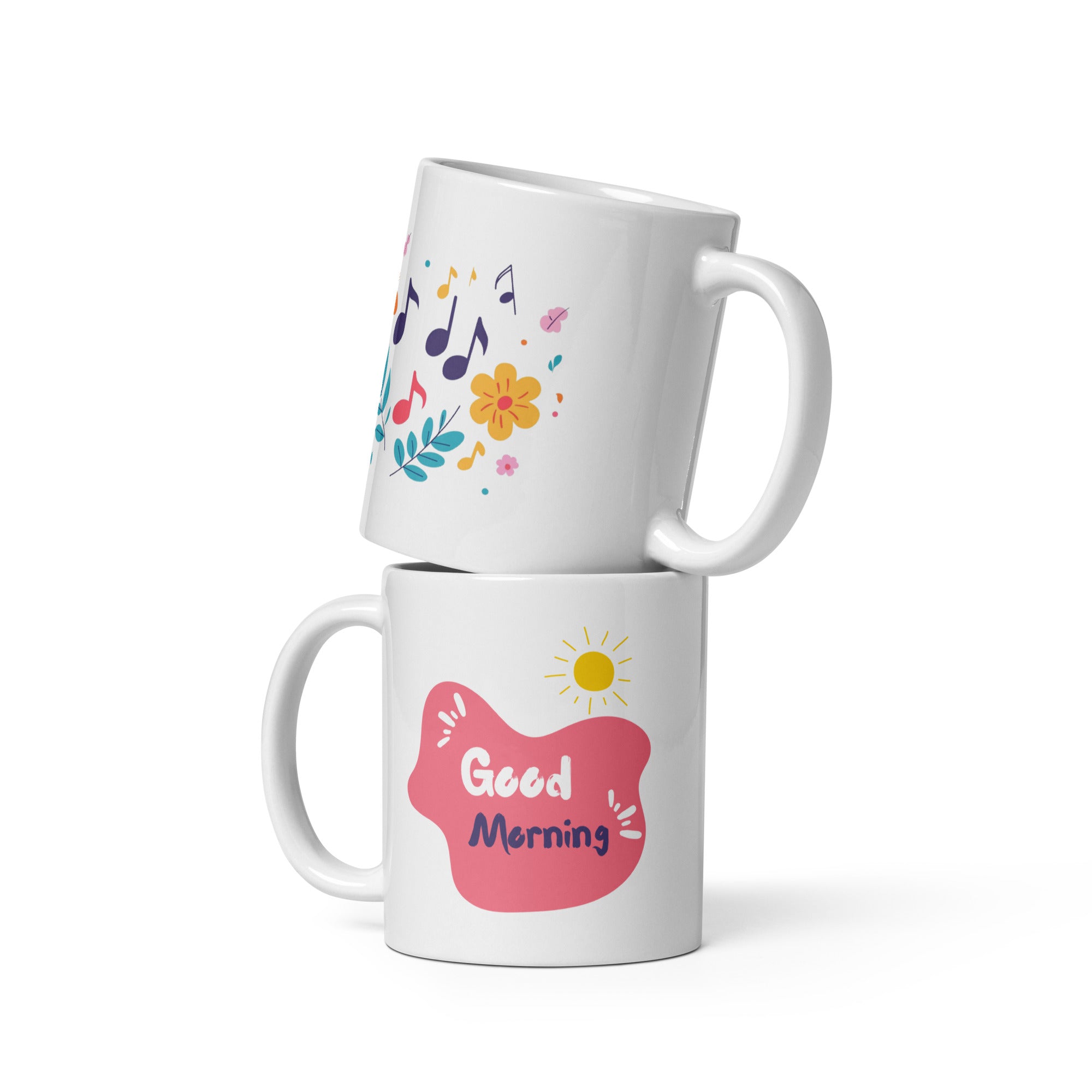 Two ceramic coffee mugs with floral and music notes designs, one with a 'Good Morning' message and the other with a sun and clouds design.