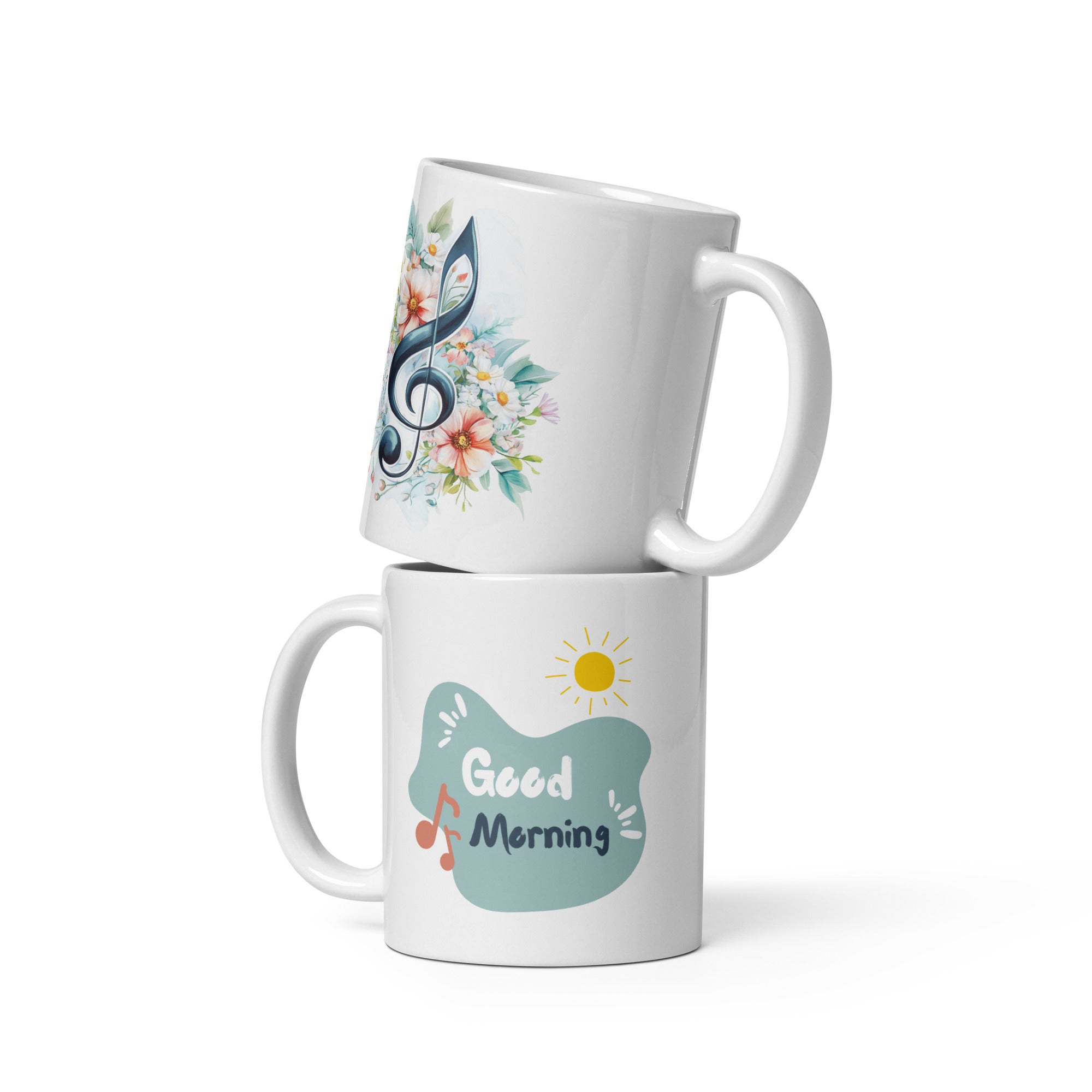Two ceramic coffee mugs with floral and musical designs. One mug has a floral treble clef design with the text 'Good Morning' and musical notes, while the other has a simple 'Good' design with a sun motif.
