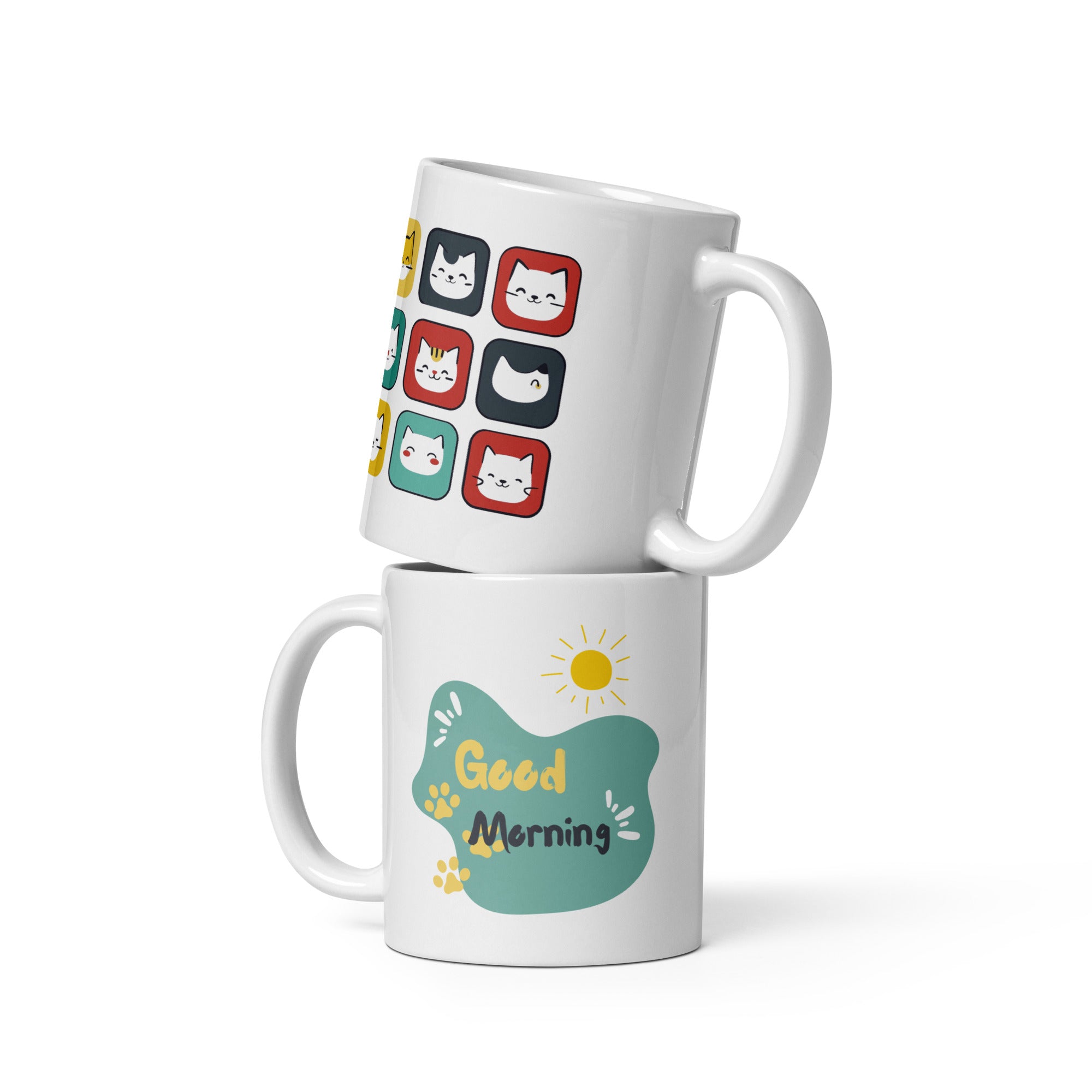 A ceramic coffee mug with a colorful cat face pattern on one side and a 'Good Morning' message with paw prints on the other, placed inside and outside of the mug.