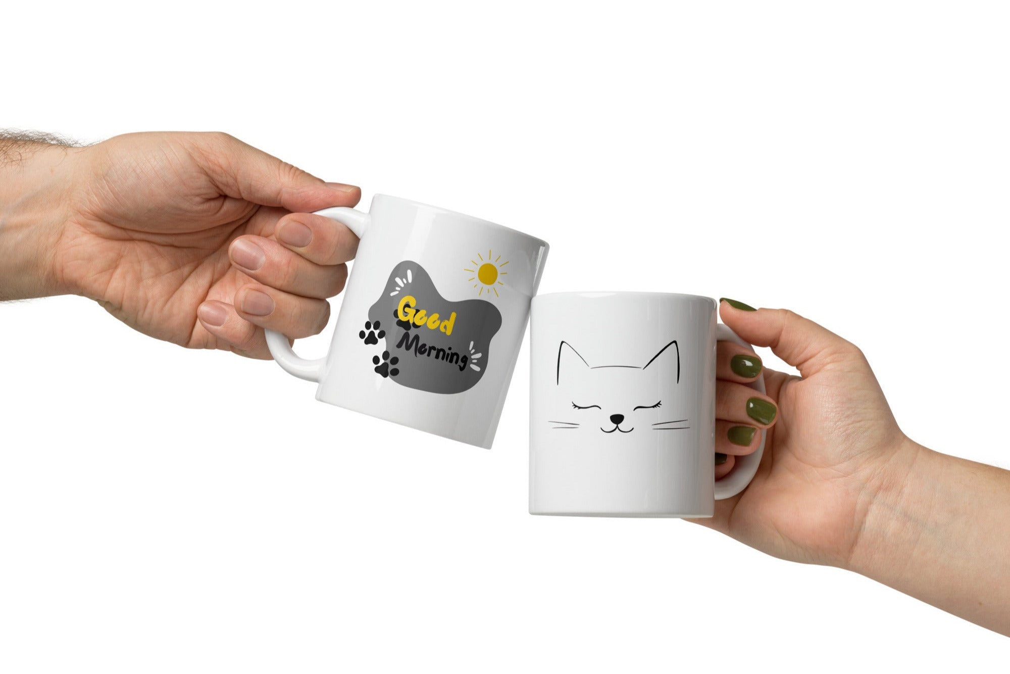 Two ceramic coffee mugs, one with a cat face illustration and 'Good Morning' text, the other with a sun design and 'Good Morning' text. Both have white interiors.