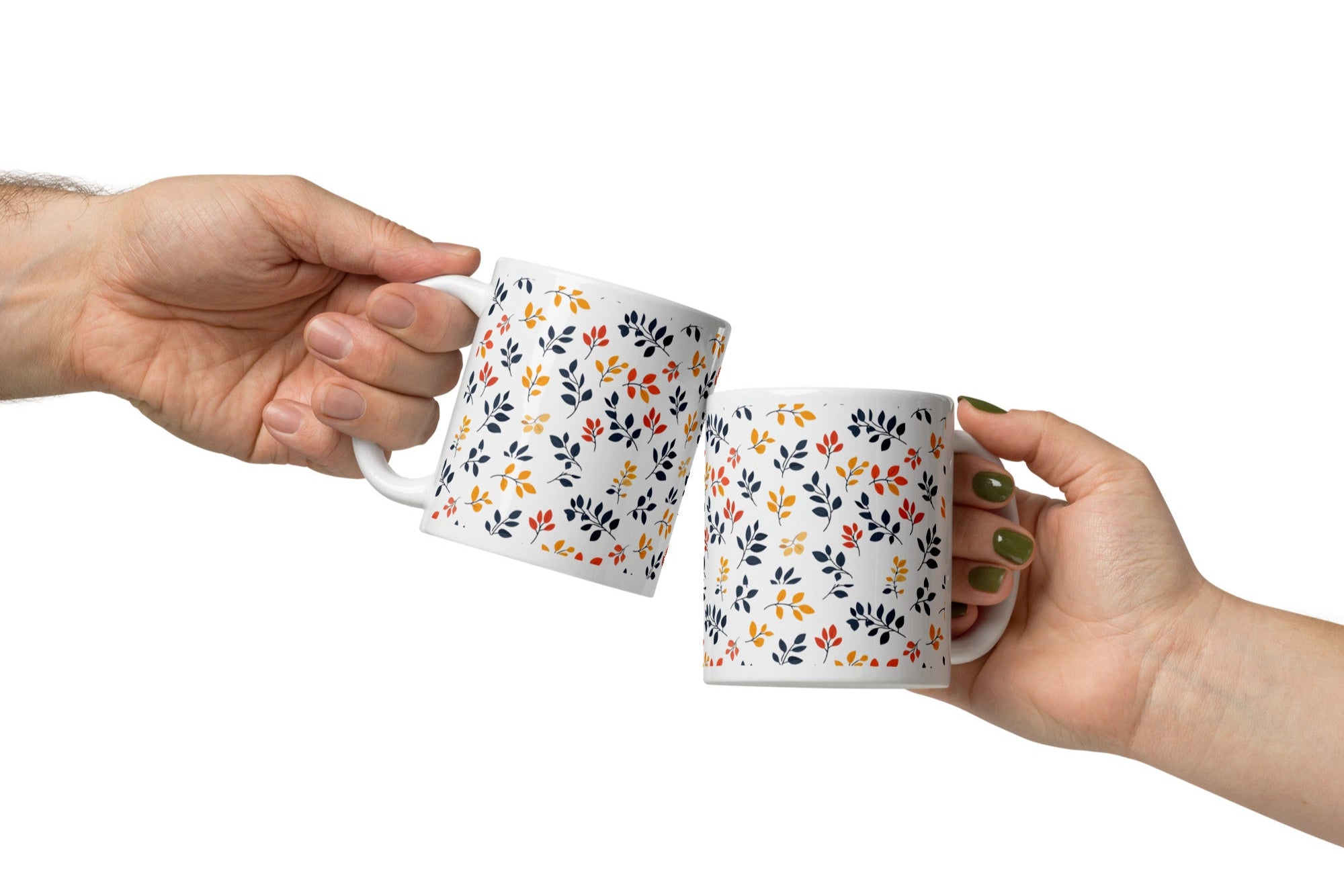 A set of two ceramic coffee mugs with a floral and autumn leaf design on a white background, one mug is filled with a liquid, possibly coffee or tea.