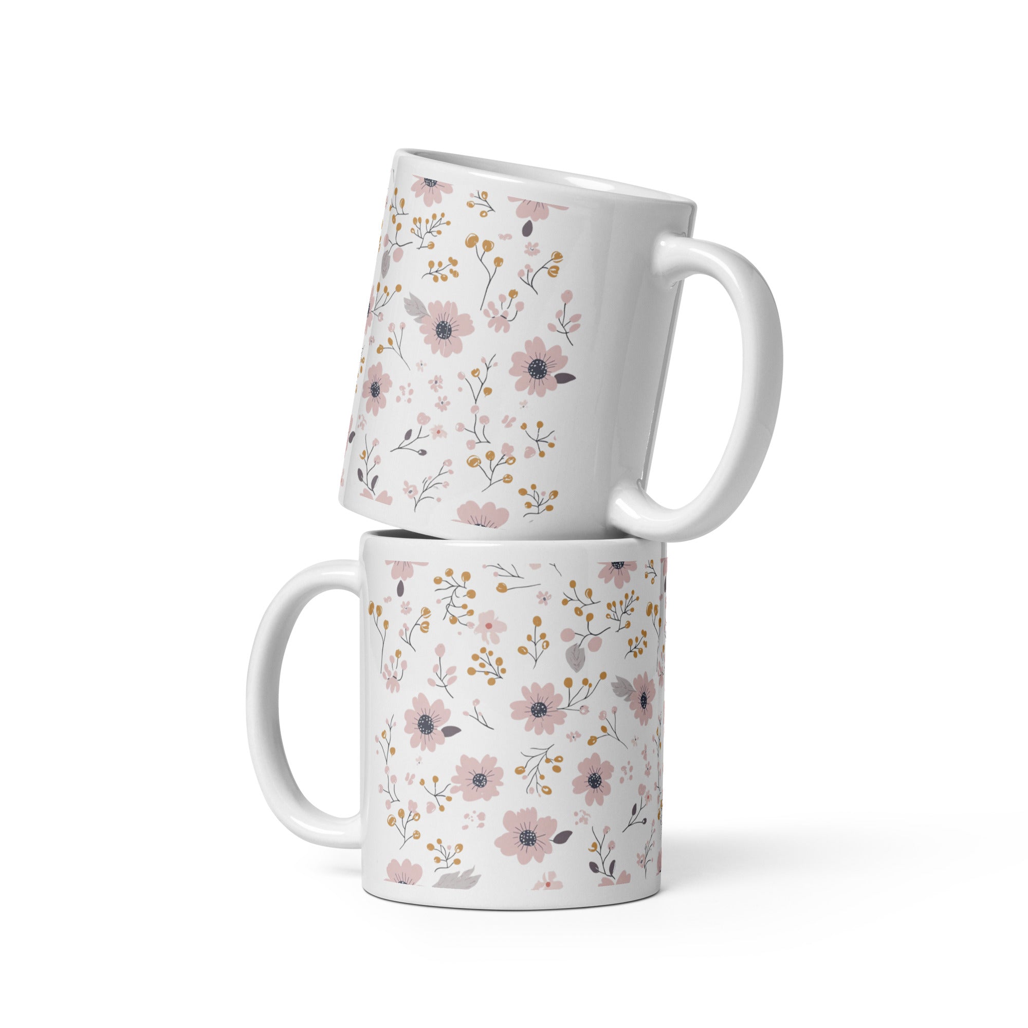 Two ceramic coffee mugs with a floral pattern, one with the handle up and the other with the handle down, on a white background.
